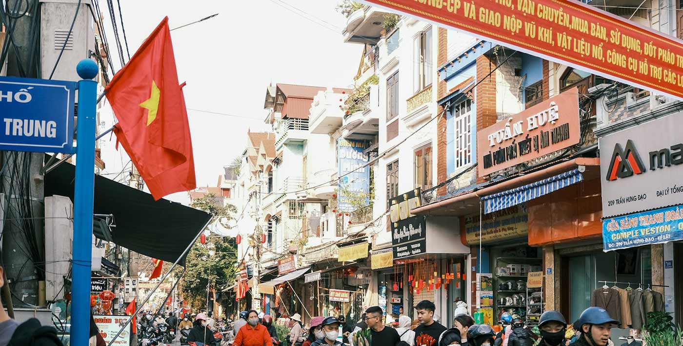 Gatebilde fra dagens Vietnam. Foto: <a href="https://unsplash.com/@duonguyen?utm_content=creditCopyText&utm_medium=referral&utm_source=unsplash">DuoNguyen</a> fra <a href="https://unsplash.com/photos/busy-street-scene-in-vietnam-with-scooters-and-flags-2mTR9QnT-LY?utm_content=creditCopyText&utm_medium=referral&utm_source=unsplash">Unsplash</a>       